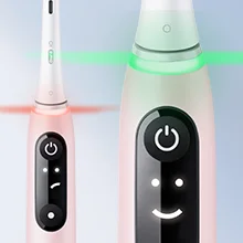 Oral-B iO toothbrush showing a red light indicating overpressure and a green light indicating correct pressure.