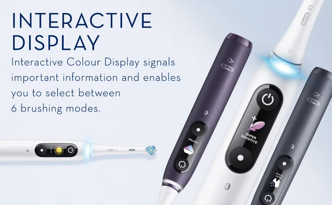 Image shows Oral-B iO electric toothbrushes displaying their interactive colour screens alongside text reading INTERACTIVE DISPLAY Interactive Colour Display signals important information and enables you to select between 6 brushing modes with examples of display text including HELLO WHITEN SUPER SENSITIVE DAILY CLEAN.