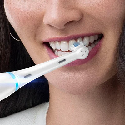 Oral-B electric toothbrush in use, demonstrating effective cleaning and a healthy, bright smile.