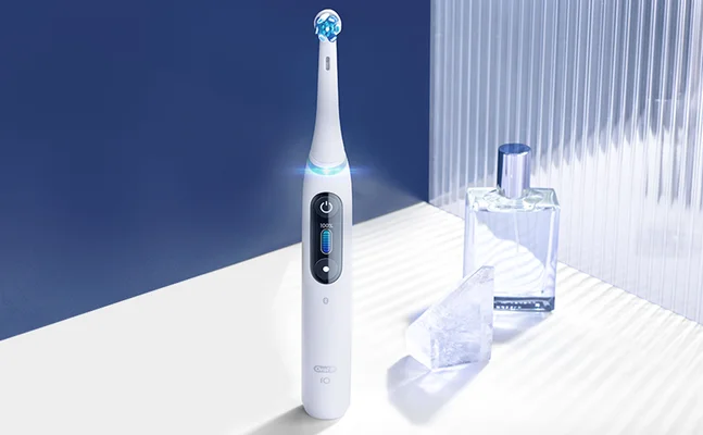 Oral-B iO electric toothbrush displaying 100% battery charge.