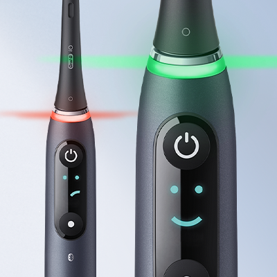 Oral-B iO toothbrush displaying both a red warning light and a green light indicating proper usage.