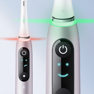Oral-B iO toothbrush showing a sad face on the left and a happy face on the right.