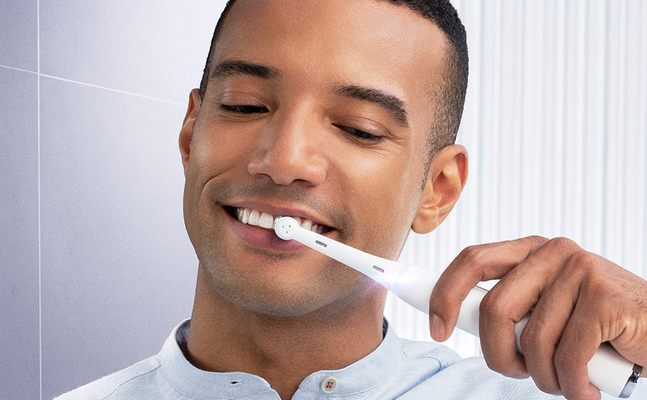 Oral-B electric toothbrush in use, highlighting the benefit of clean and healthy teeth.