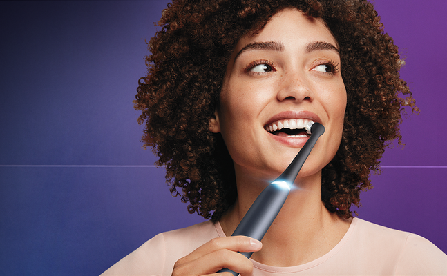 Oral-B toothbrush in use, demonstrating its sleek design and compact brush head for effective cleaning.