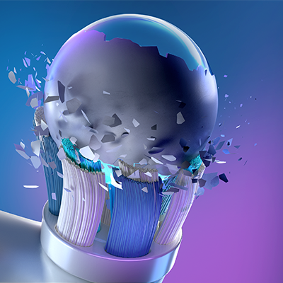 Oral-B toothbrush head breaking through a sphere, illustrating the power of cleaning.