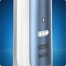 Close up of a blue and white Oral-B electric toothbrush handle showing a bluetooth icon and a battery level indicator with three bars followed by Oral-B Braun text.