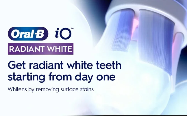 A close-up of an Oral-B iO toothbrush head with glowing bristles next to the Oral-B iO logo and text reading Oral-B iO RADIANT WHITE Get radiant white teeth starting from day one Whitens by removing surface stains.