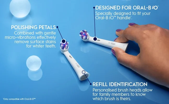 Two Oral-B electric toothbrush heads are shown on a blue background, one held by a hand, with text describing features POLISHING PETALS Combined with gentle micro-vibrations effectively remove surface stains for whiter teeth. DESIGNED FOR ORAL-B iO Specially designed to fit your Oral-B iO™ handle*. REFILL IDENTIFICATION Personalised brush heads allow for family members to know which brush is theirs. *Only compatible with Oral-B iO™.