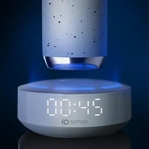 Oral-B iO Sense charger showing a digital clock display with blue light emanating from the base.