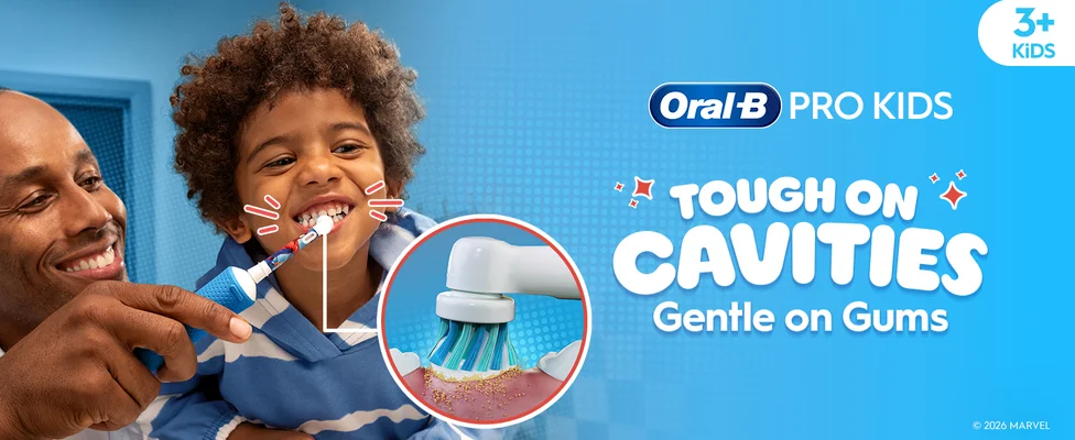 Smiling child brushing teeth with the help of an adult using an Oral-B Spider-Man toothbrush. Highlight on the round brush head. Text: “Tough on Cavities, Gentle on Gums.”