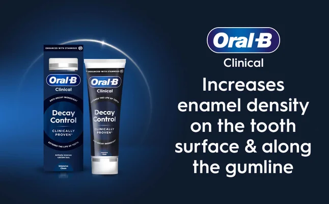 A box and tube of Oral-B Clinical toothpaste is shown alongside text that reads Oral-B Clinical Increases enamel density on the tooth surface & along the gumline and text on the packaging including Decay Control CLINICALLY PROVEN ENHANCED WITH STANNOUS.