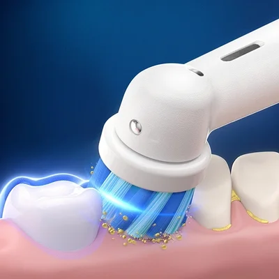 Oral-B electric toothbrush cleaning a tooth, removing plaque and debris with sonic vibrations.
