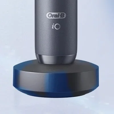 Oral-B iO toothbrush shown charging on its magnetic charging base.