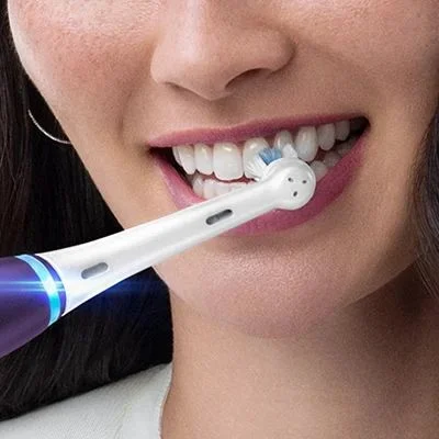 Oral-B electric toothbrush in use, demonstrating effective cleaning for healthy gums and a bright smile.