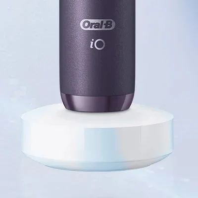Oral-B iO toothbrush in charging dock, showing the product's sleek design and charging capability.