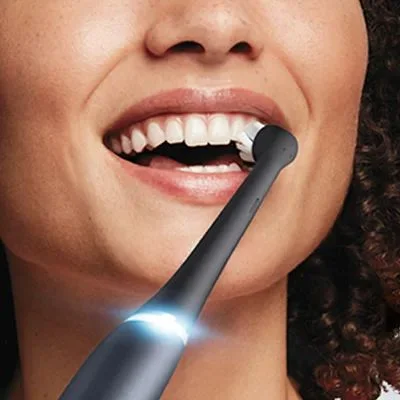 Oral-B electric toothbrush in use, demonstrating effective cleaning of teeth and gums.