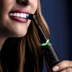 Oral-B toothbrush in use, highlighting clean teeth and a healthy smile.