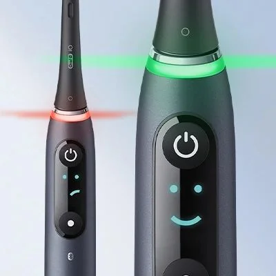 Oral-B iO toothbrush displaying a happy face icon and green light, indicating optimal brushing.