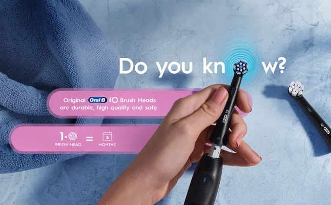 Hand holds Oral-B iO brush head that lasts for 3 months, making it less than 4 € a month.