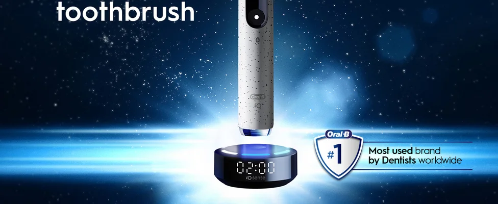 An Oral-B iO electric toothbrush is shown on its iO sense charger displaying 02:00, next to an Oral-B shield icon with the text #1 Most used brand by Dentists worldwide, with the word toothbrush at the top left.