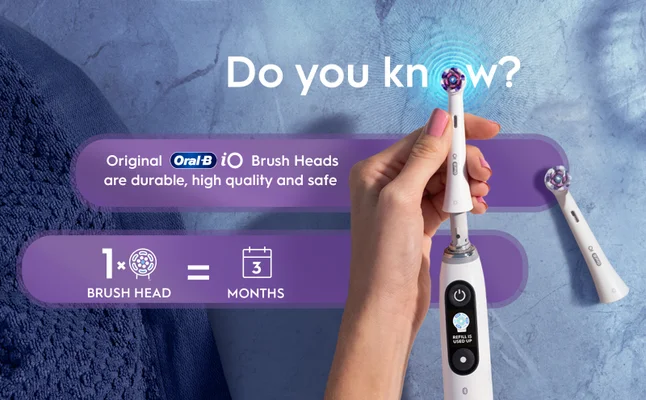 Hand holds Oral-B iO brush head that lasts for 3 months, making it less than 4 € a month.