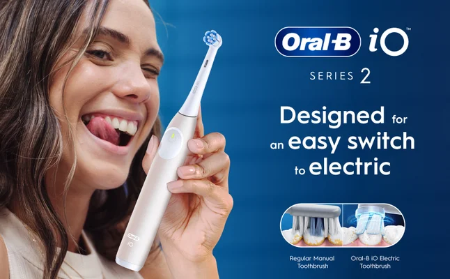 Close-up of a woman with an Oral-B iO Series 2 electric toothbrush, designed for an easy switch to electric.