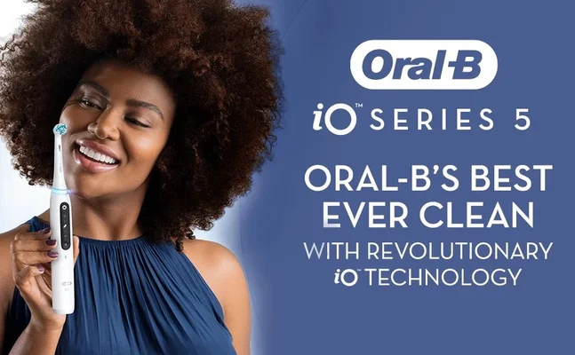 A woman with curly hair smiles while holding an electric toothbrush; text on the image includes Oral-B, iO Series 5, Oral-Bs Best Ever Clean, with Revolutionary iO Technology.