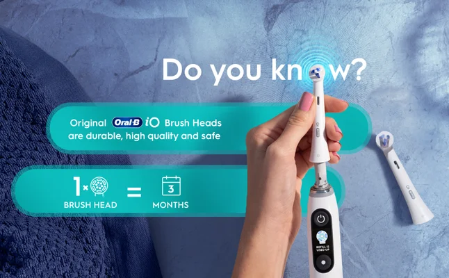 Hand holds Oral-B iO brush head that lasts for 3 months, making it less than 4 € a month.