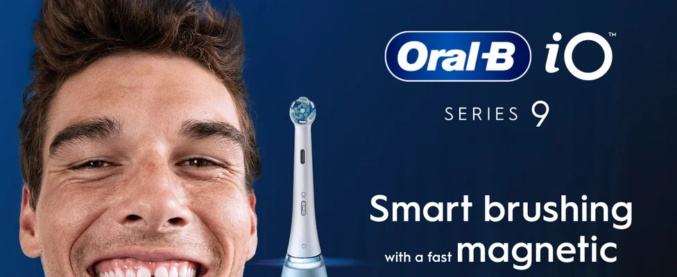 A man smiling broadly next to an Oral-B iO electric toothbrush with the text Oral-B iO SERIES 9 Smart brushing with a fast magnetic.