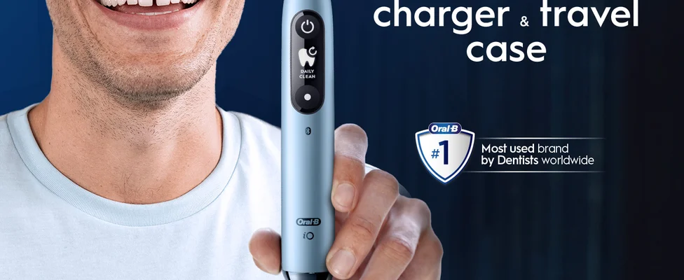 A man smiles holding a light blue Oral-B iO toothbrush displaying DAILY CLEAN, with overlaid text reading charger & travel case Oral-B #1 Most used brand by Dentists worldwide.