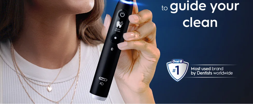 A hand holding an Oral-B toothbrush with a claim 'To guide your clean, #1 dentist-recommended brand'