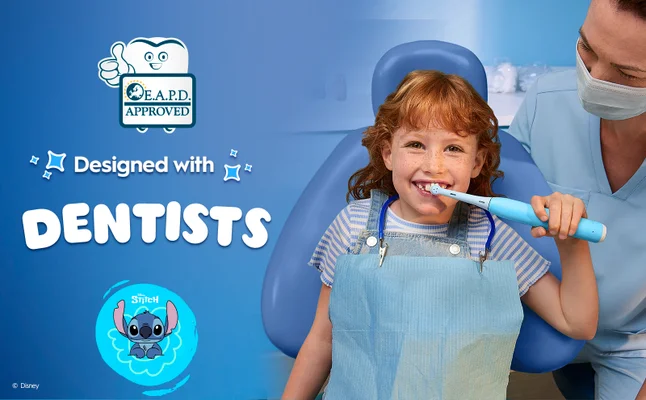 A dentist and a kid in a dentist chair holding iO Kids 6+ that was designed with dentists.