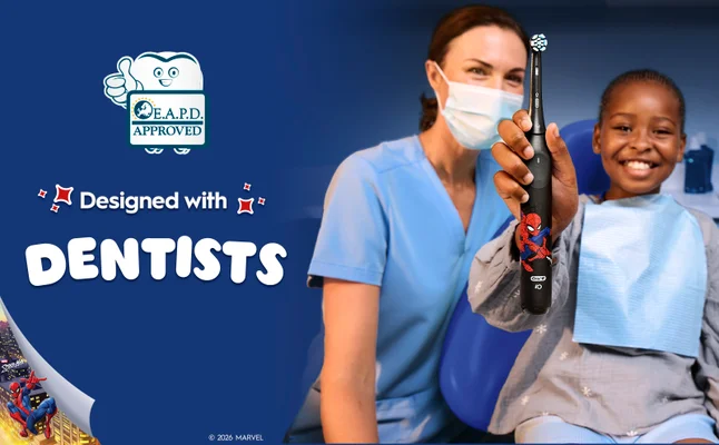 A dentist and a kid in a dentist chair holding iO Kids 6+ that was designed with dentists.