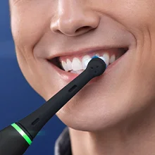 Oral B toothbrush in use, demonstrating cleaning of teeth in a close-up shot.